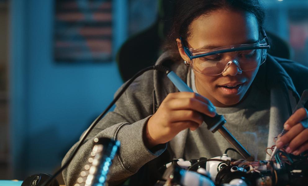 Young woman working on robotic components